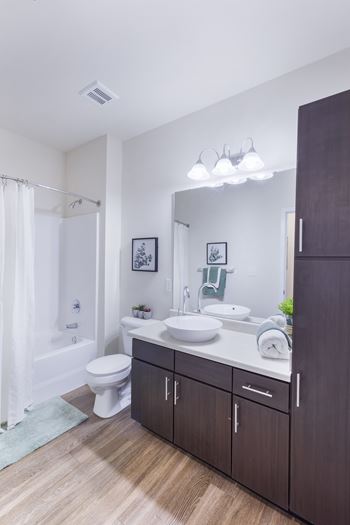 A bathroom with a white toilet, a white sink, and a white shower curtain.